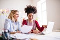 Young creative women with laptop in a studio, startup business. Royalty Free Stock Photo