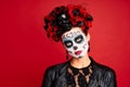 Young creepy lady calavera. wears artistic make-up for the feast of all the dead. dressed in a black leather jacket with a wreath