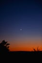 Young crescent moon on a clear sky at the end of the day in the summer Royalty Free Stock Photo