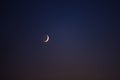 Young crescent moon on a clear sky at the end of the day in the summer Royalty Free Stock Photo