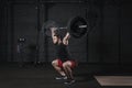 Young cross fit athlete doing squats with barbell over head. Man practicing functional training.Powerlifting workout exercises