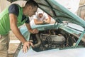 Young Cuban men discussing car renovation project