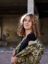 Young curly blond military woman, wearing ukrainian army military uniform and black t-shirt, posing. Three-quarter portrait of