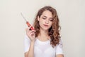 Young curly brunette ineptly holds a screwdriver Royalty Free Stock Photo