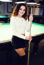 Young curly girl posed near billiard table