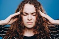 young curly hair woman suffering from headache desperate and stressed because pain and migraine. Hands on head Royalty Free Stock Photo