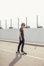 Boy riding longboard on boardwalk, warm summer time Royalty Free Stock Photo