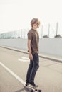 Boy riding longboard on boardwalk, warm summer time Royalty Free Stock Photo