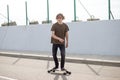 Boy riding longboard on boardwalk, warm summer time Royalty Free Stock Photo