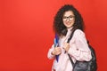 Young curly student woman wearing backpack glasses holding books and tablet over isolated red background Royalty Free Stock Photo