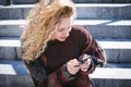 Young curly woman using her phone and relax in the city Royalty Free Stock Photo