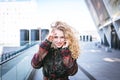 Young curly woman using her phone and relax in the city Royalty Free Stock Photo