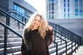 Young curly woman using her phone and relax in the city Royalty Free Stock Photo