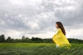 Young woman standing with silk shawl in meadow Royalty Free Stock Photo