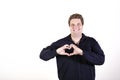 Young curvy man posing in a white background isolated smiling and showing a heart shape with hands Royalty Free Stock Photo
