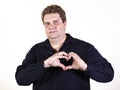 Young curvy man posing in a white background isolated smiling and showing a heart shape with hands Royalty Free Stock Photo