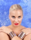 A young, curvy woman with arms crossed on her shoulders with wide bracelets.