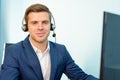 Young Customer Support Phone Operator with Headset at his Working Place in Office. Royalty Free Stock Photo