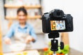 Young cute Asian blogger girl recording video tutorial session of salad cooking lesson at home kitchen. Food blogging concept Royalty Free Stock Photo