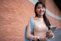 Young and cute Asian college student girls smile carrying a backpack with a textbooks in front of the university campus building. Royalty Free Stock Photo