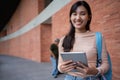 Young and cute Asian college student girls smile carrying a backpack with a textbooks in front of the university campus building. Royalty Free Stock Photo