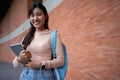 Young and cute Asian college student girls smile carrying a backpack with a textbooks in front of the university campus building. Royalty Free Stock Photo