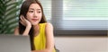 Young cute Asian office woman sitting daydreaming and look sideways to the copy space to the right at the desk in the office, Royalty Free Stock Photo