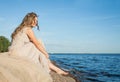 Young cute barefoot girl model in a beige dress on the beach