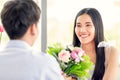 A young and cute beautiful Asian woman and her boyfriend talking with love and happiness. There is colorful bouquet between them. Royalty Free Stock Photo