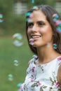 Young cute brunette girl smiling in the park. soap bubbles Royalty Free Stock Photo