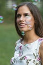 Young cute brunette girl smiling in the park. soap bubbles Royalty Free Stock Photo