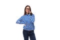 young cute brunette lady in a blue striped casual blouse speaks on the phone