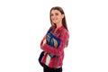 Young cute brunette student woman with blue backpack on her shoulder and folder for notebooks in hands looking at the Royalty Free Stock Photo