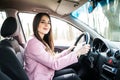 Young cute brunette woman driving a car.