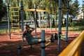 Active lifestyle concept. Young cute Caucasian man shakes his abs on street sports ground equipped with exercise equipment. Royalty Free Stock Photo