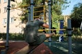 Active lifestyle concept. Young cute Caucasian man shakes his abs on street sports ground equipped with exercise equipment. Royalty Free Stock Photo