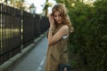 Young cute charming woman in a fashionable summer vest in a stylish white T-shirt posing in a park on a sunny day