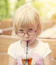 Young cute child drink with straw ice tea from bottle