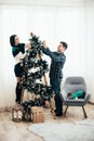 Young cute couple decorate a Christmas tree on Christmas Eve