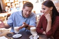 Young cute couple drinking latte sitting in the restaurant