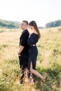 Young cute couple in love, wearing stylish black clothes, posing outdoor in summer meadow. Sensual romantic portrait of Royalty Free Stock Photo