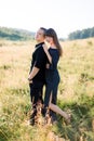 Young cute couple in love, wearing stylish black clothes, posing outdoor in summer meadow. Sensual romantic portrait of Royalty Free Stock Photo