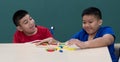 Young and cute disabled two boys study and playing together in classroom with love and intimate pose