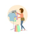 Young cute excited woman choosing clothes, shopping in mall Royalty Free Stock Photo