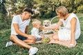 Young cute family on picnic with dog Royalty Free Stock Photo