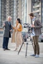 Young cute female reporter talking to a famous businessman