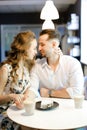 Young cute girl and boy sitting at cafe, drinking coffee and resting. Royalty Free Stock Photo