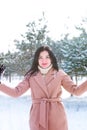 Young cute girl with durk hair has fun in snowy weather in winter in the park. Royalty Free Stock Photo