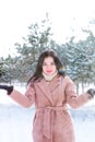 Young cute girl with durk hair has fun in snowy weather in winter in the park. Royalty Free Stock Photo