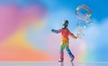 Young cute girl in a fashionable rainbow suit walking with soap bubbles floating in the air Royalty Free Stock Photo